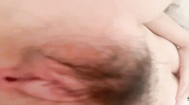 無邪気なショートヘアの少女がベッドの上で裸の自撮りをする