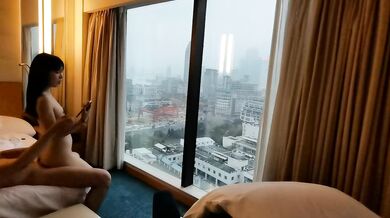 カップルは窓の外の美しい景色を眺めながらホテルの部屋でセックスをした