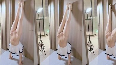 Cô gái mặc đồ thủy thủ buộc tóc đuôi ngựa đang đứng bằng tay